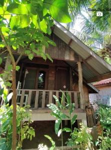 drewniany dom z werandą w ogrodzie w obiekcie Sala Thongyon - Guest House w mieście Savannakhét
