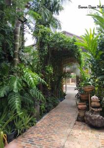 een bakstenen loopbrug in een tuin met planten bij Sala Thongyon - Guest House in Savannakhet