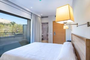 a bedroom with a white bed and a large window at HOTEL JAUME D'URGELL in Balaguer