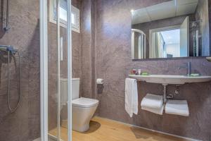 a bathroom with a toilet and a sink and a shower at HOTEL JAUME D'URGELL in Balaguer