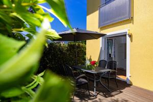 une terrasse avec une table, des chaises et un parasol dans l'établissement Appartements Walzl, à Maria Lankowitz