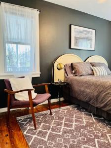 ein Schlafzimmer mit einem Bett, einem Stuhl und einem Fenster in der Unterkunft Modern Cottage The Whitney by The Bay in Villas
