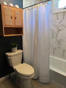 a bathroom with a toilet and a shower curtain at Modern Cottage The Whitney by The Bay in Villas