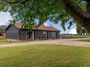 a building with a grassy field in front of it at The Old Workshop in Gipping