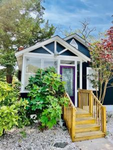 una pequeña casa azul con puerta morada y porche en Modern Cottage The Whitney by The Bay en Villas