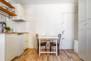 une petite cuisine avec une table et des chaises dans l'établissement Nice and bright studio close to Paris - Pantin - Welkeys, à Pantin