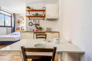 - une cuisine avec une table, des chaises et un lit dans l'établissement Nice and bright studio close to Paris - Pantin - Welkeys, à Pantin