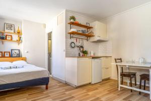 Cet appartement comprend une chambre avec un lit et une cuisine avec une table. dans l'établissement Nice and bright studio close to Paris - Pantin - Welkeys, à Pantin