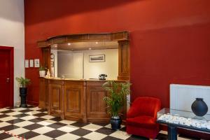 Habitación con espejo y pared roja. en Hotel Palladion, en Ermoupoli