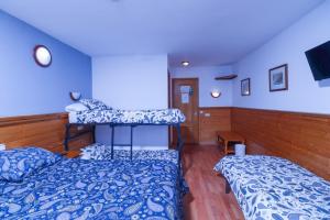 two beds in a room with blue walls at Hotel Merino in Pas de la Casa
