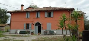 una casa arancione con tavolo e sedie di Agriturismo La Riccardina a Budrio