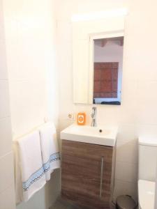 a white bathroom with a sink and a mirror at Estudio Don Antonio en el centro de La Laguna in La Laguna +1 photo