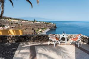 einen Tisch und Stühle auf einer Terrasse mit Meerblick in der Unterkunft Casa Los Mangos - Increíbles vistas in Playa de Santiago