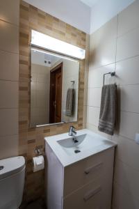 a bathroom with a sink and a toilet and a mirror at Casa Los Mangos - Increíbles vistas in Playa de Santiago