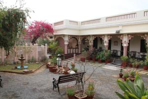 einen Innenhof mit einer Bank und vielen Topfpflanzen in der Unterkunft Badnor House - The Heritage Homestay in Ajmer