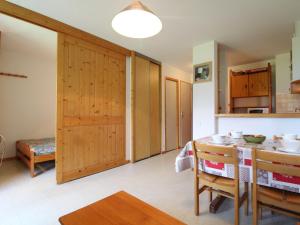 a kitchen with wooden doors and a table and chairs at Appartement Termignon, 2 pièces, 4 personnes - FR-1-508-128 in Termignon