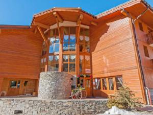 a large wooden building with a large window at Appart cosy 6 pers, proche pistes, WiFi, parking, draps inclus - FR-1-508-117 in Lanslevillard +5 photos