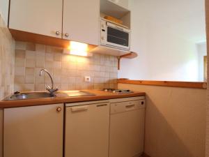 eine kleine Küche mit einer Spüle und einer Mikrowelle in der Unterkunft Appartement Termignon, 2 pièces, 4 personnes - FR-1-508-128 in Termignon