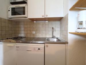 una cucina con armadi bianchi e lavandino di Appartement Termignon, 2 pièces, 4 personnes - FR-1-508-192 a Termignon