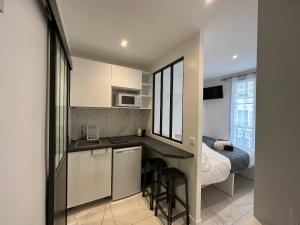 a kitchen with a desk and a bed in a room at Beatrice et Emmanuel Meublé Eiffel in Paris