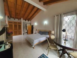 Un dormitorio con una cama y una mesa. en Villa Luz en Santa Marta