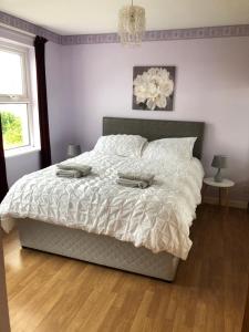 a bedroom with a bed with a white comforter at Conveniently situated three bedroom townhouse in Moville