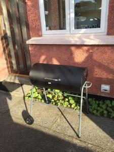 a black grill sitting in front of a building at Conveniently situated three bedroom townhouse in Moville