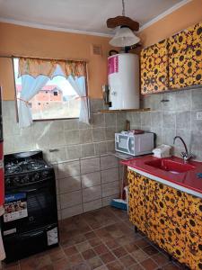 エル・チャルテンにあるComplejo Las Marasのシンクとコンロのあるキッチン +7枚の写真