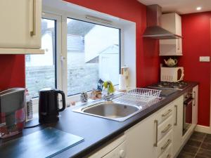 a kitchen with a sink and a window at Mallams in Castletown