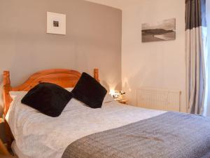 a bedroom with a bed with two pillows on it at Mallams in Castletown