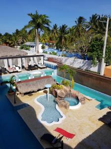 a resort swimming pool with chairs and a beach at El Cabarete Boutique Hotel in Cabarete