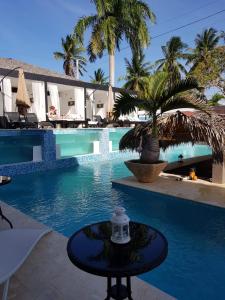 a pool with a table in front of a resort at El Cabarete Boutique Hotel in Cabarete