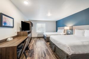 a hotel room with two beds and a desk and a tv at Extended Stay America Suites - Philadelphia - Plymouth Meeting - West in Plymouth Meeting +27 photos