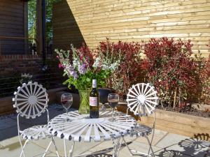 a table with a bottle of wine and two chairs at The Hayloft-ukc2489 in Mountfield