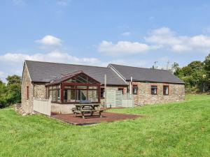 a stone house with a picnic table in front of it at Swallow Cottage in Gowerton