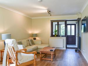 uma sala de estar com um sofá e uma mesa em Swallow Cottage em Gowerton