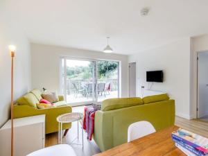 a living room with a green couch and a table at The Lake House in Oakford