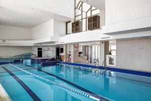 a large swimming pool with blue water in a building at Blue Dream Marina View big 1bd ap pool parkimg gym in Herzliyya B