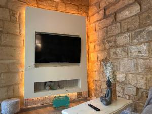 a living room with a stone wall with a flat screen tv at Moi in Birkirkara