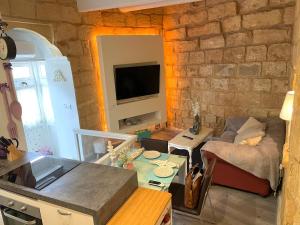a kitchen and living room with a stone wall at Moi in Birkirkara