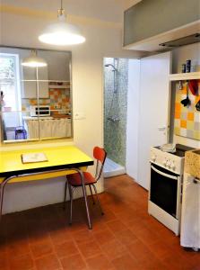 uma cozinha com uma mesa amarela e duas cadeiras em La Cachette village em Roussillon
