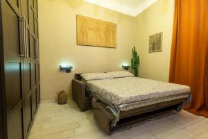 ein Schlafzimmer mit einem Bett in der Ecke eines Zimmers in der Unterkunft Monolocale vicino alla Stazione e all’Expò in Genua