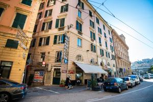 ein Gebäude in einer Stadtstraße mit geparkten Autos in der Unterkunft Monolocale vicino alla Stazione e all’Expò in Genua