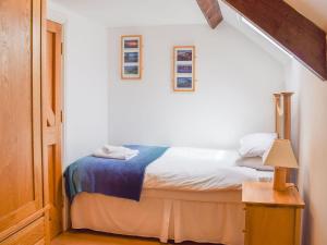 a bedroom with a bed with a blue blanket on it at The Granary in Westerdale