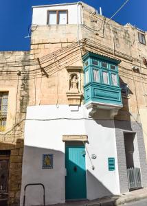 a building with a green door and a window at Moi in Birkirkara