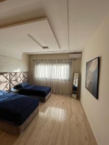 duży pokój z 2 łóżkami i oknem w obiekcie RAWAN RESIDENCY w mieście Wadżda