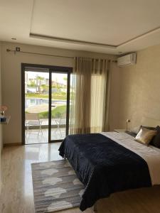 a bedroom with a large bed and a balcony at RAWAN RESIDENCY in Oujda