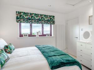 um quarto com uma grande cama branca e uma janela em The Birds Nest em Longridge