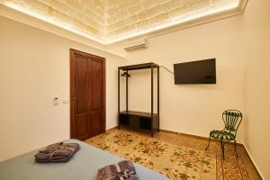 um quarto com uma cama, uma cadeira e uma televisão em Casa Piti Stunning View em Favignana