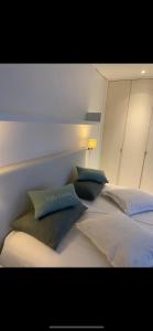 a bed with three pillows on top of it at Villa Emilia in De Haan